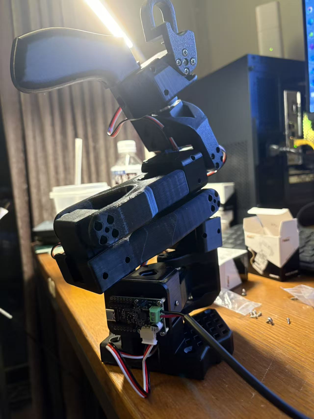 已经组装成形的黑色 SO-101 主动臂，底部可以看到控制板和舵机线
