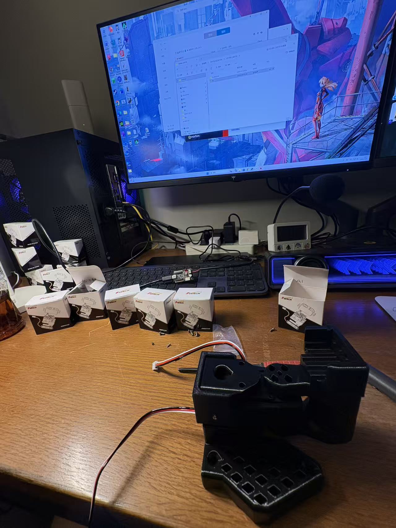桌面上摆放着 SO-101 舵机、控制板、3D 打印件和正在组装的主动臂